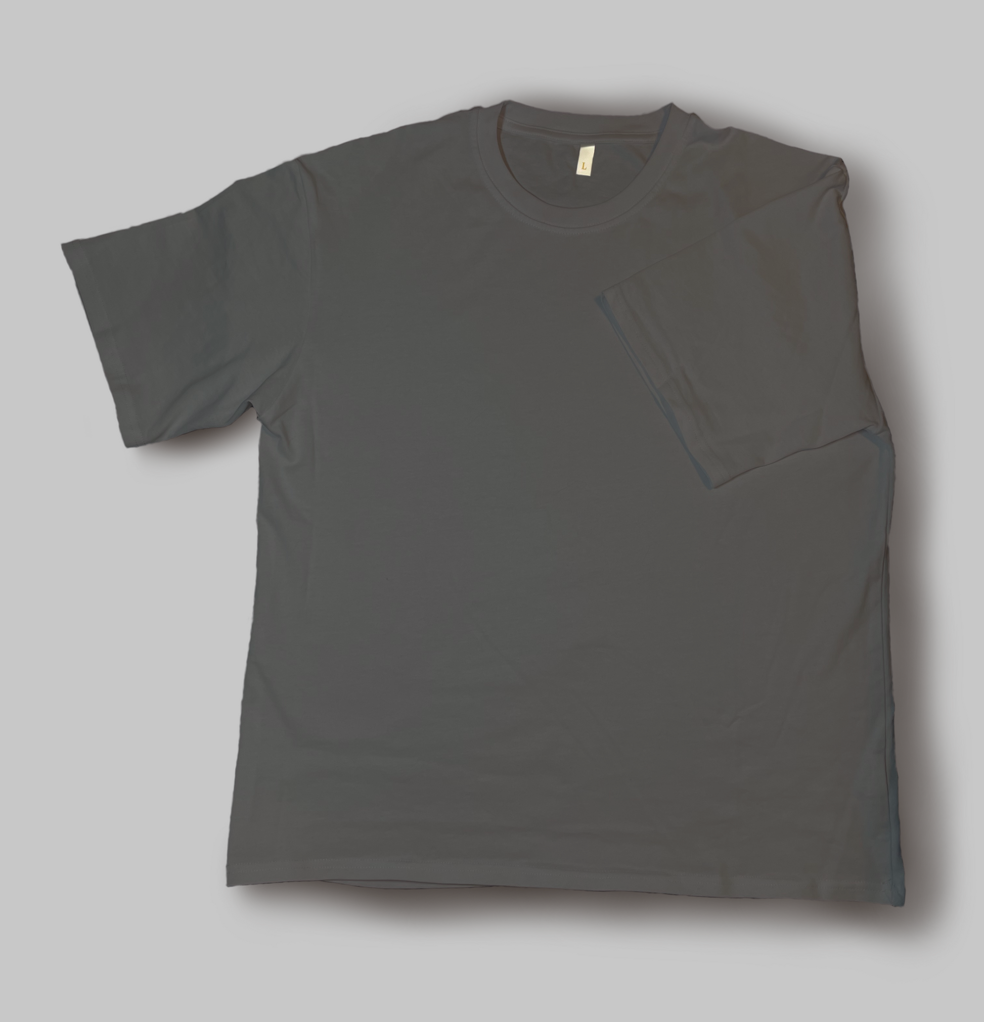 A gray cotton T Shirt laid out flat with a sleeve folded into the middle of the shirt