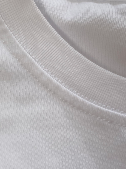 A close up photo of the texture of a white cotton t shirt around the neck line and its stitching